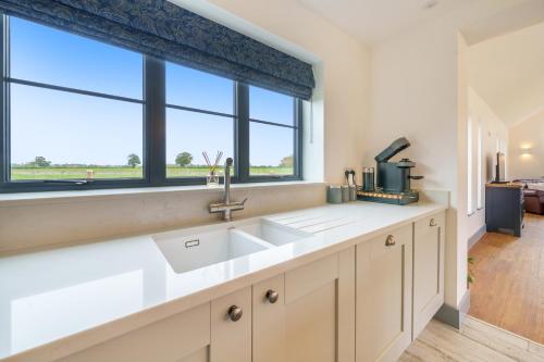 a kitchen with a sink and a window at EASTFIELD HOUSE in Whissonsett