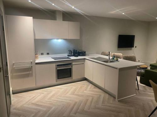 a kitchen with white cabinets and a counter top at Luxurious 1 Bed - CITY VIEWS in Liverpool