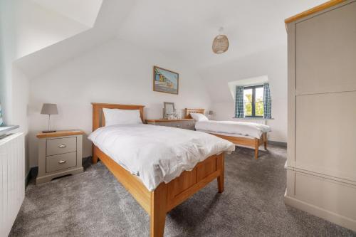 a bedroom with two beds and a mirror at EASTFIELD HOUSE in Whissonsett