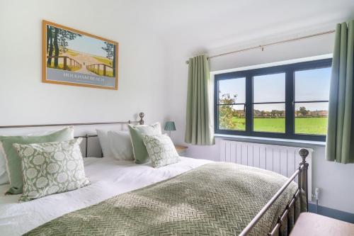 a bedroom with a bed and a large window at EASTFIELD HOUSE in Whissonsett