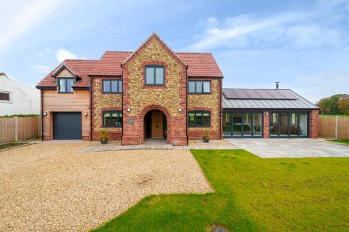 a large brick house with a garage at EASTFIELD HOUSE in Whissonsett