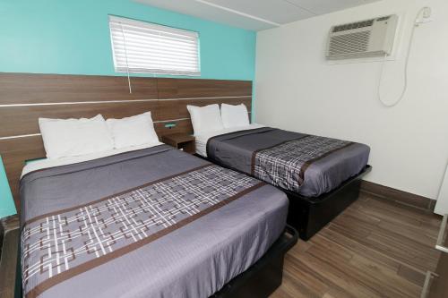 um quarto de hotel com duas camas e uma janela em Marjac Suites Virginia Beach Oceanfront em Virginia Beach