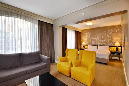 a hotel room with a bed and two chairs and a couch at The Capetonian - Halal in Cape Town