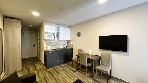 een keuken en eetkamer met een tafel en een televisie bij New Gudauri Loft 2 - Mountain Harmony, Quiet & Cosy Place Next to Main Lift in Goedaoeri