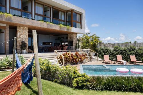 a villa with a swimming pool and a resort at Mansão Vista de 180º para Mar na Rota dos Milagres in Passo de Camarajibe
