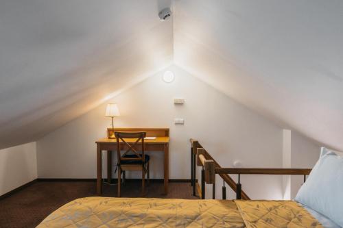 a bedroom with a desk and a bed and a desk and chair at CATHEDRAL Old Town Suites in Vilnius