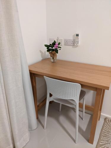 a wooden desk with a chair and a vase of flowers at Seaview serenity apartment in Flic-en-Flac