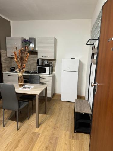 Una pequeña cocina con una mesa y un refrigerador. en Civico 19 2PAX, en Sassari