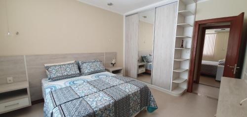 1 dormitorio con cama y espejo grande en Casa Vista Pontal, en Ilhéus