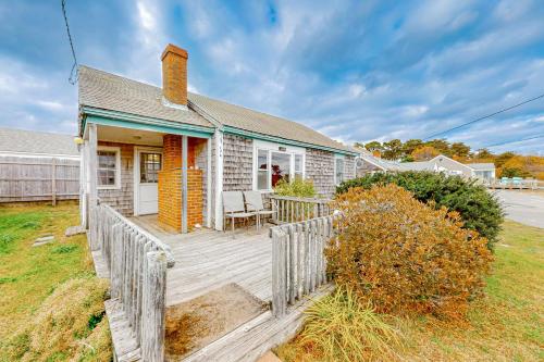 a house with a wooden porch with a fence at The Jib & The Genoa in Dennis Port