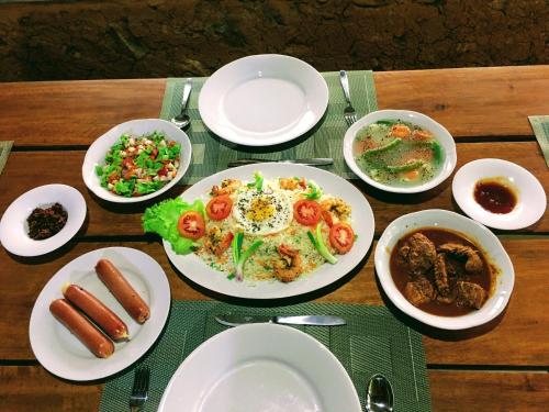 a table with plates and bowls of food on it at The Vintage Villa - Knuckles in Rangala