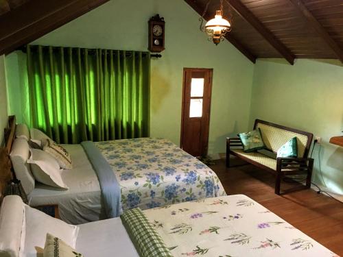 a bedroom with two beds and a window with green curtains at The Vintage Villa - Knuckles in Rangala