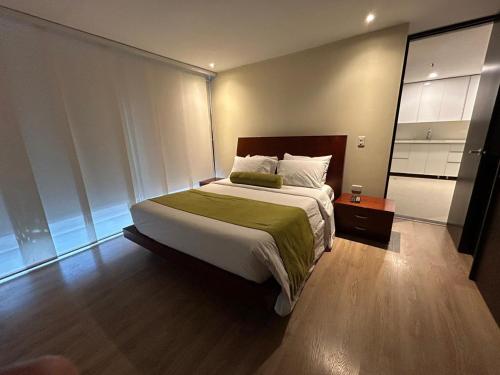 ein Schlafzimmer mit einem großen Bett und einem Spiegel in der Unterkunft Suite Presidencial en hotel próximo al aeropuerto in Rionegro