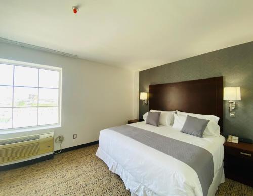 a hotel room with a large bed and a window at La Quinta by Wyndham Reynosa in Reynosa