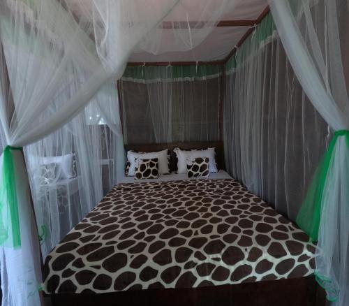 a bedroom with a black and white bed with curtains at Nature World Udawalawe in Udawalawe