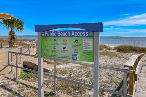 a sign at a beach with the ocean in the background at Sunshine Haven in Carrabelle