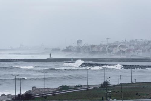 a view of the ocean with waves and a city at Golden Tulip Porto Gaia in Vila Nova de Gaia
