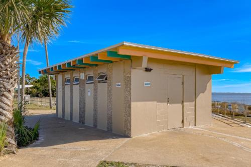 a small building with four doors and a palm tree at Sunshine Haven in Carrabelle