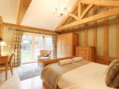 a bedroom with a bed and a desk and a chair at Lodge Cottage in Harwich