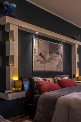 a bedroom with a bed and a large painting on the wall at Lisetta Rooms in Vernazza