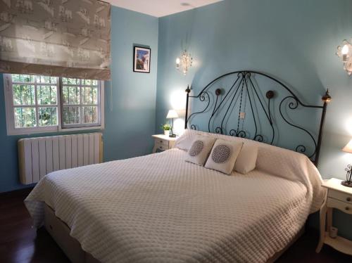 sypialnia z dużym łóżkiem z niebieskimi ścianami w obiekcie Casa Adelfa w Marbelli