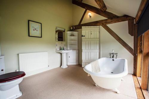 uma casa de banho com uma banheira branca e um WC. em Cwm Pelved is a large 6 bedroom holiday home close to Hay on Wye - with incredible views em Hereford