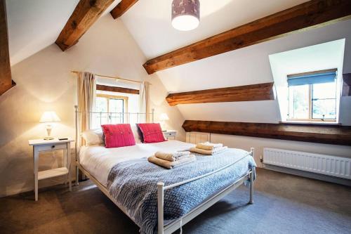 um quarto com uma cama com almofadas vermelhas e uma janela em Cwm Pelved is a large 6 bedroom holiday home close to Hay on Wye - with incredible views em Hereford