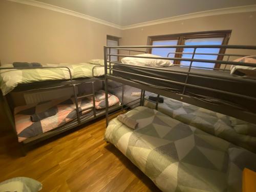 um quarto com 3 beliches e uma janela em Dublin Airport Big rooms with bathroom outside room - kitchen only 7 days reservation em Dublin