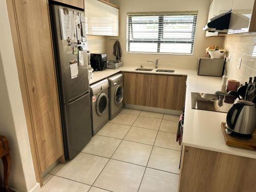 a kitchen with a washer and dryer in it at Sunny Shores Hideaway in Cape Town
