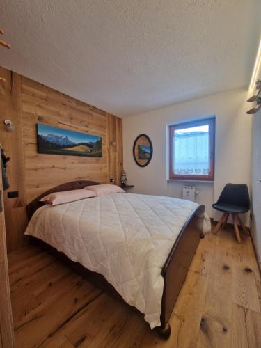 a bedroom with a large bed with a wooden wall at L'Atelier du Temps - Il Nido al Noce in Morgex