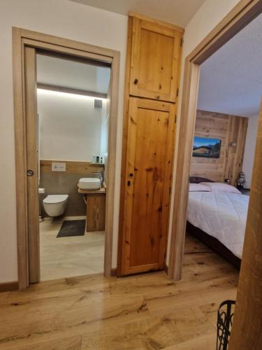 a bedroom with a bed and a bathroom with a mirror at L'Atelier du Temps - Il Nido al Noce in Morgex