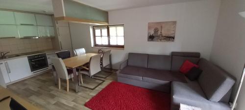 a kitchen and a living room with a table and a couch at S4 Resort Kouty in Loučná nad Desnou