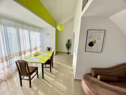 a dining room with a table and chairs and a couch at Banićević APARTMANI in Ðenovići