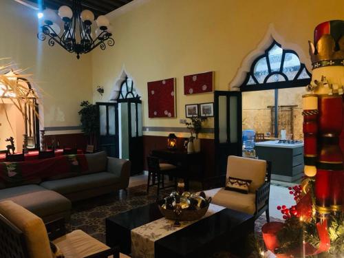 a living room with a couch and a table at Bella Casa Colonial González con Piscina in Campeche