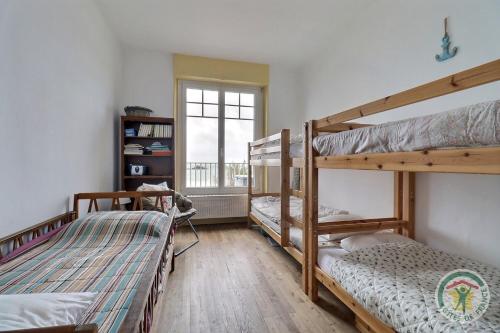 2 łóżka piętrowe w pokoju z oknem w obiekcie Cote mer w Saint-Malo