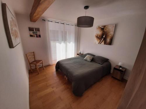 1 dormitorio con 1 cama y 1 silla en Kezeg ar lann, en Lauzach