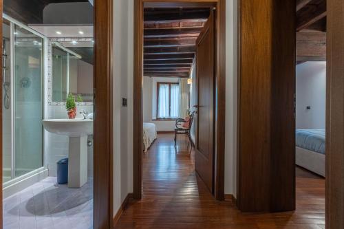 a hallway with a sink and a bathroom at Exclusive Duplex Apartment in the City Center x9! in Ferrara