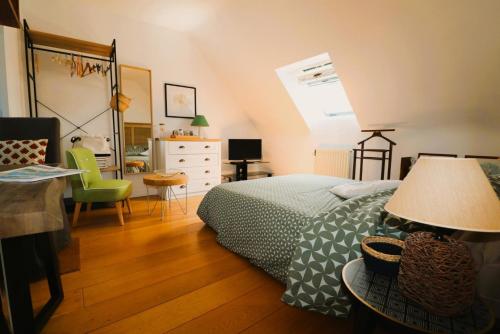 een slaapkamer met een bed, een bureau en een stoel bij La petite hermine in Saint-Malo