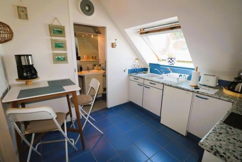 een kleine keuken met blauwe tegelvloeren en een tafel en stoelen bij La petite hermine in Saint-Malo