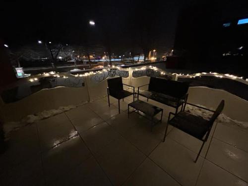 twee stoelen en een tafel op een dak 's nachts bij Superior - Central Rooftop - 20min to Hamburg in Elmshorn