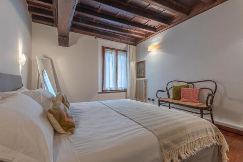 ein Schlafzimmer mit einem großen weißen Bett und einem Stuhl in der Unterkunft Exclusive Duplex Apartment in the City Center x9! in Ferrara