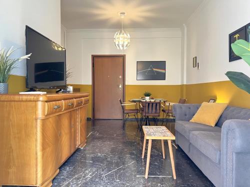 a living room with a couch and a tv at Athenian Vintage Style 2 bdr apartment in Athens