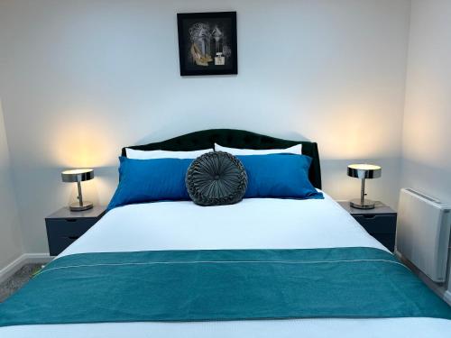 ein Schlafzimmer mit einem großen Bett mit blauen Kissen in der Unterkunft Aqua Dream Luxury Apartment-Coyles Place at Portland 88 in Belfast