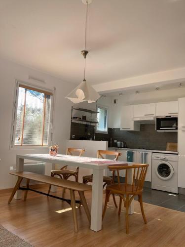 une cuisine avec une table et des chaises dans une pièce dans l'établissement Le GLAZ * Grande plage & commerces à pied * Jardin, à Carnac