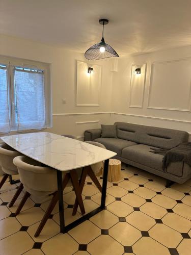 un salon avec une table et un canapé dans l'établissement Appartement Haut Standing, à Orléans