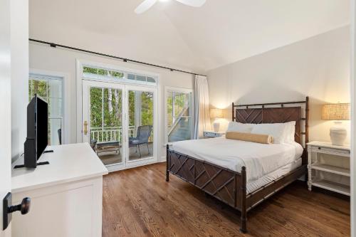 a bedroom with a bed and a desk with a television at 18 Ocean Green in Kiawah Island