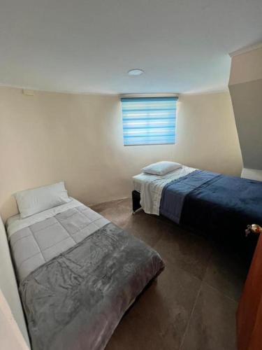 a bedroom with two beds and a window at Entre Dunas y Caracolas in Punta de Choros