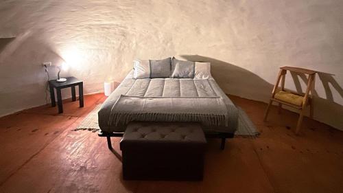 a bedroom with a bed and a chair in a room at Entre Dunas y Caracolas in Punta de Choros