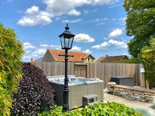 a hot tub in a garden with a street light at La Maison de Manolie in Courcelles-Sapicourt