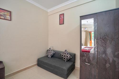 a living room with a couch and a mirror at Hotel Leela Inn Candolim in Marmagao